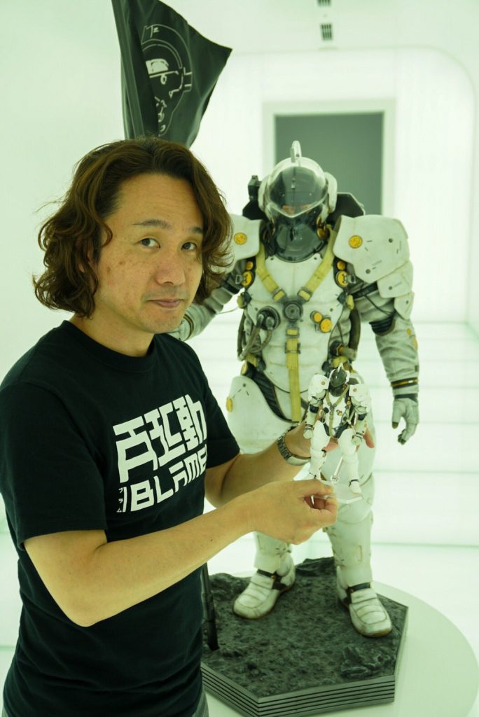 Yoji Shinkawa tenant dans ses mains la figurine Figma de Ludens, devant la statuette de Ludens par Prime 1 Studio,  le 25 mai 2017