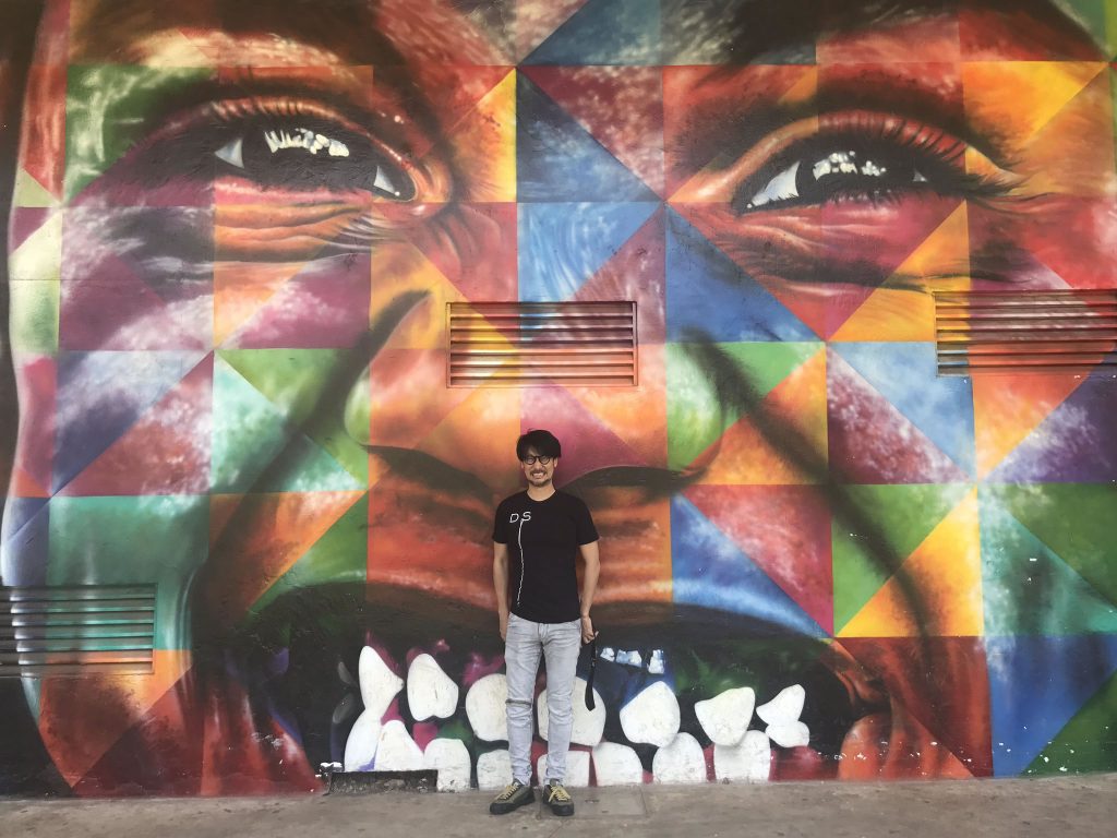 Hideo Kojima pose devant une fresque de l'artiste brésilien Eduardo Kobra à São Paulo, le 13 octobre 2017